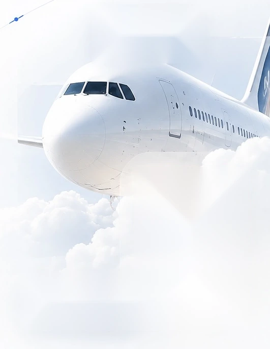 A white airliner above soft clouds