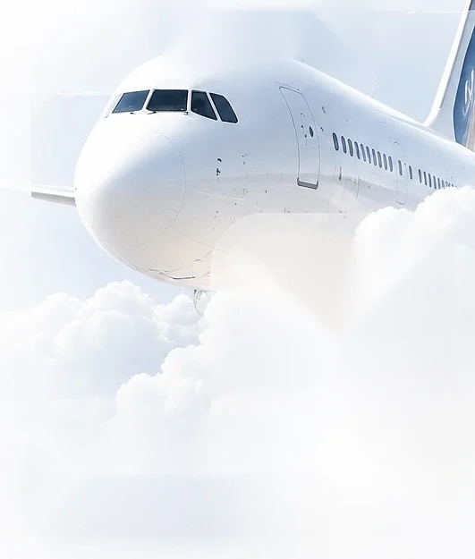 A white airliner above soft clouds